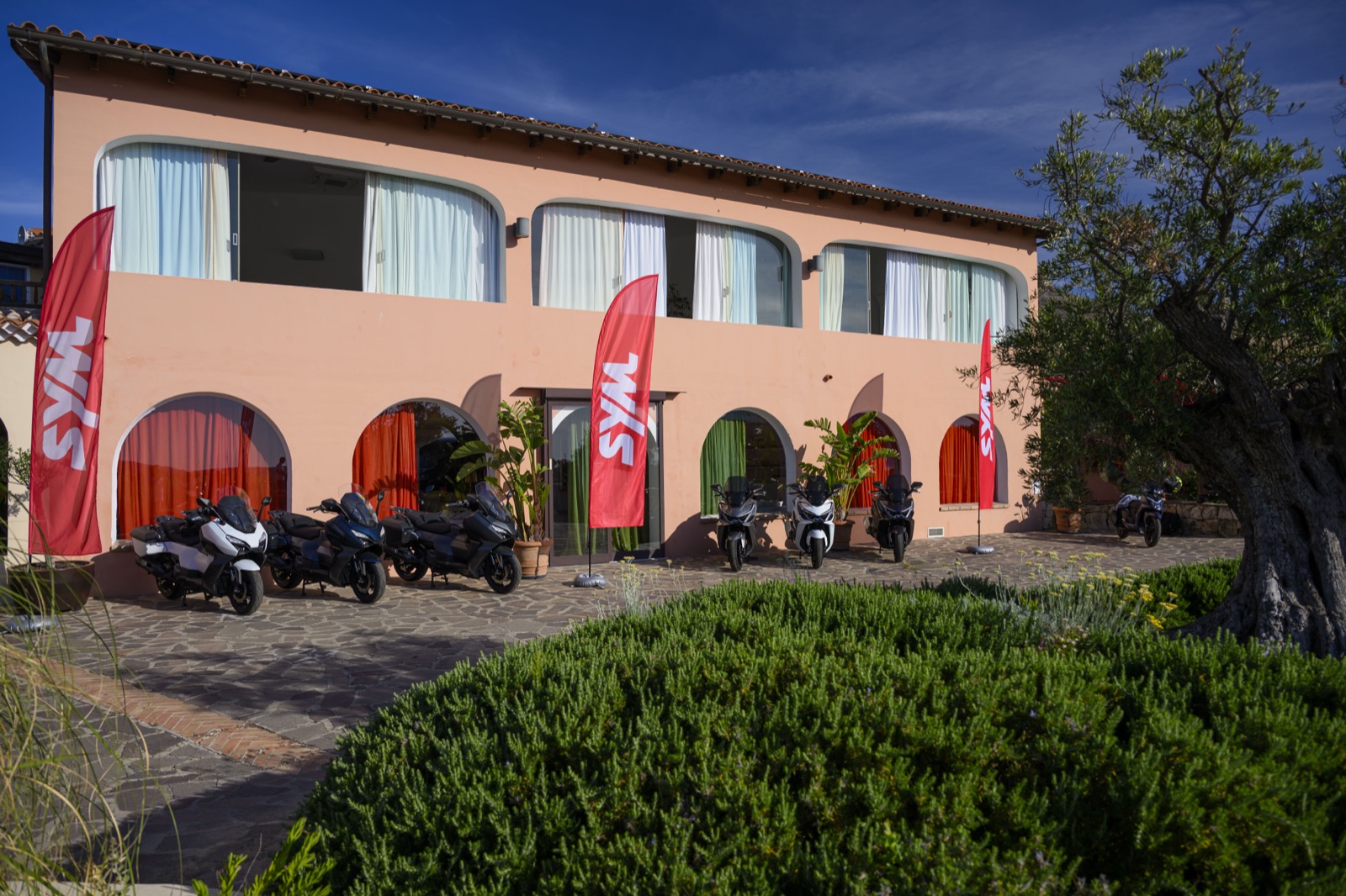 Gli scooter SYM allestiti davanti alla struttura con le bandiere del brand